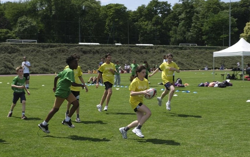 Les collégiens jouant au rugby sur la pelouse