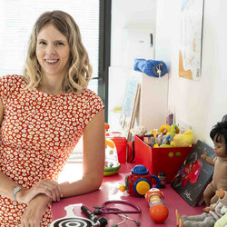 Océane Guers, accoudée sur une table couverte de jouets, Antony, SST13