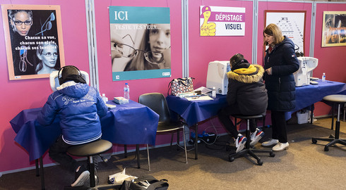 Jeunes assis de dos devant des stands de d&eacute;pistage sant&eacute;, dans le hall du gymnase Pierre B&eacute;r&eacute;govoy de Ch&acirc;tenay-Malabry