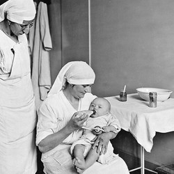 Deux infirmières nourrissant un bébé