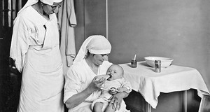 Deux infirmières nourrissant un bébé