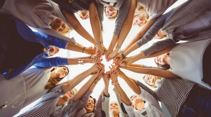 mains de femmes qui forment un cercle vues du bas