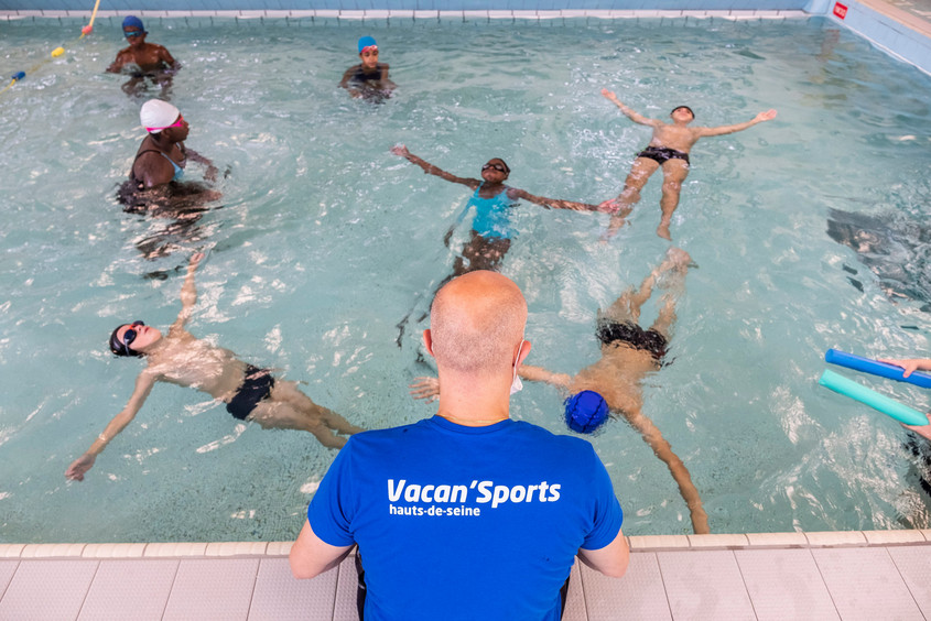 Maitre nageur sur le bord du bassin avec des jeunes de Vacan'Sports