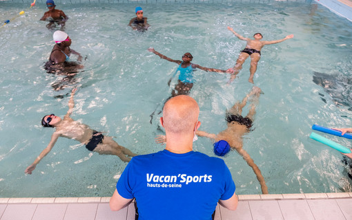 Maitre nageur sur le bord du bassin avec des jeunes de Vacan'Sports