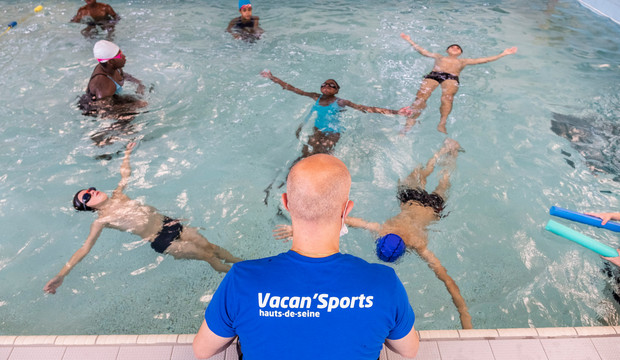Maitre nageur sur le bord du bassin avec des jeunes de Vacan'Sports