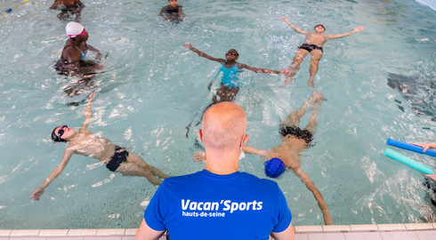 Maitre nageur sur le bord du bassin avec des jeunes de Vacan'Sports