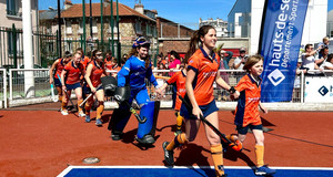 Jeune qui entre sur le terrain avec une des joueuses pro