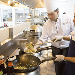 un chef et une cuisinière prépare un plat dans une cuisine 