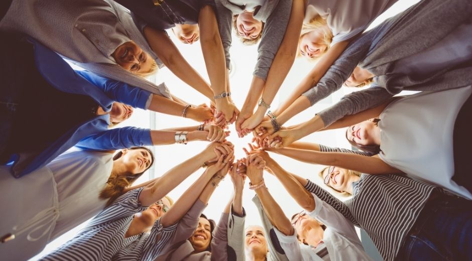 mains de femmes qui forment un cercle vues du bas